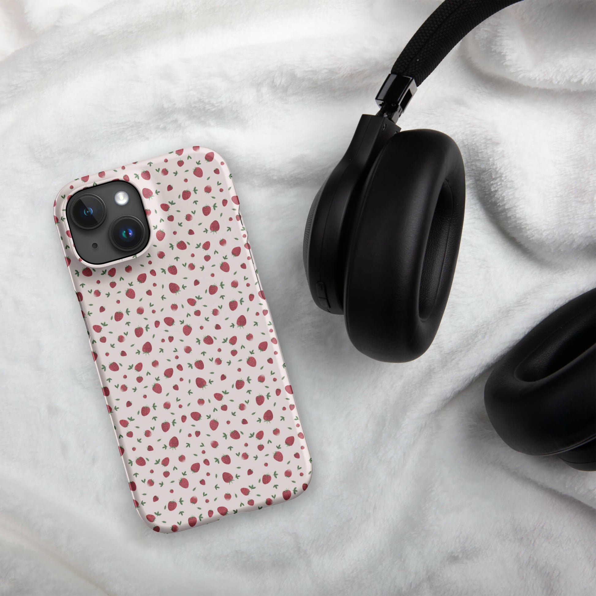 Strawberry pink iPhone case mockup on fabric with headphones