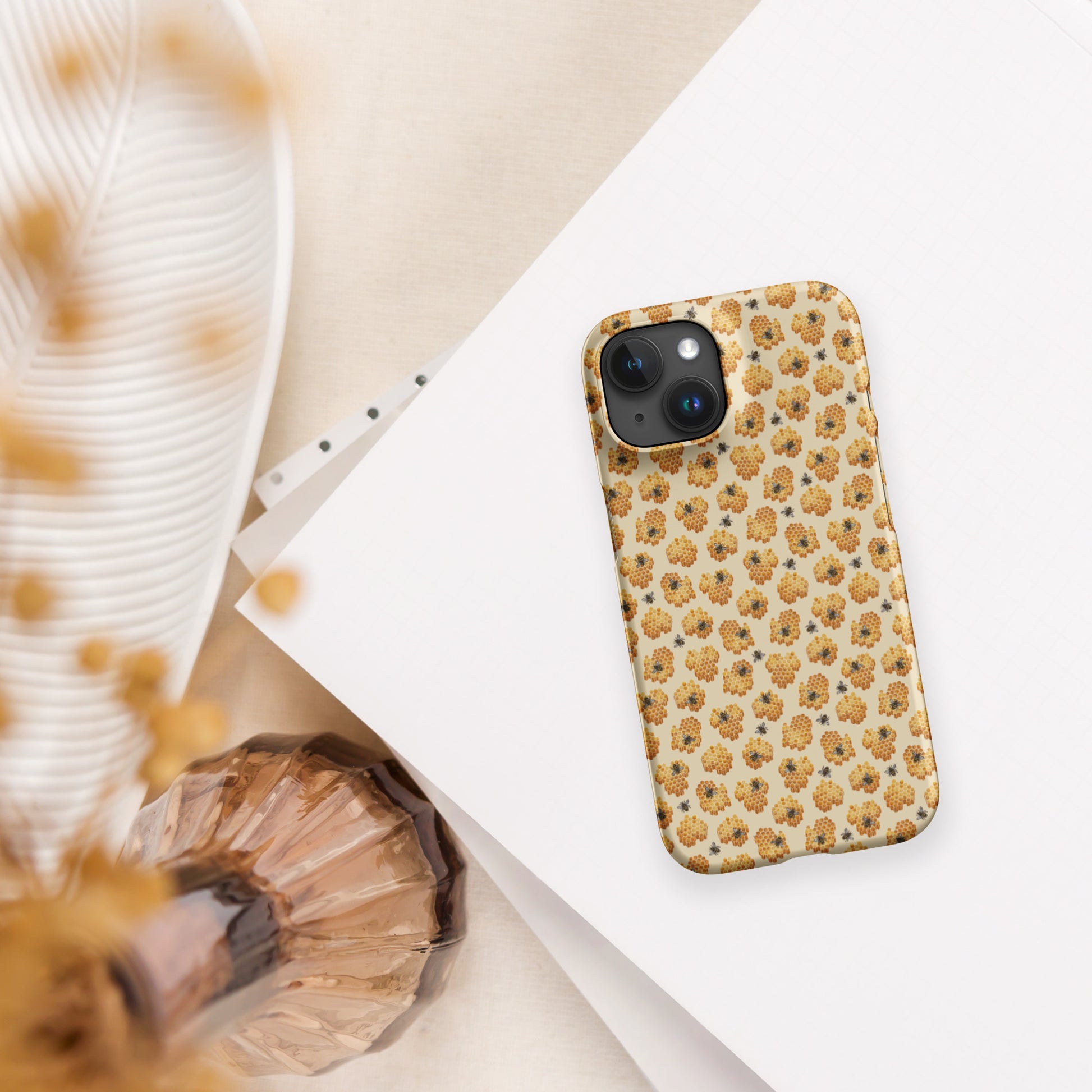 Yellow phone case with honeybee pattern on table