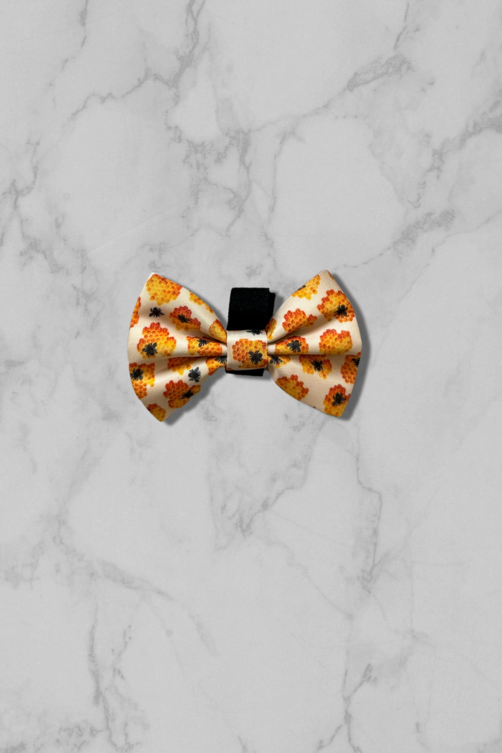 Yellow honey dog bow tie on marble tile